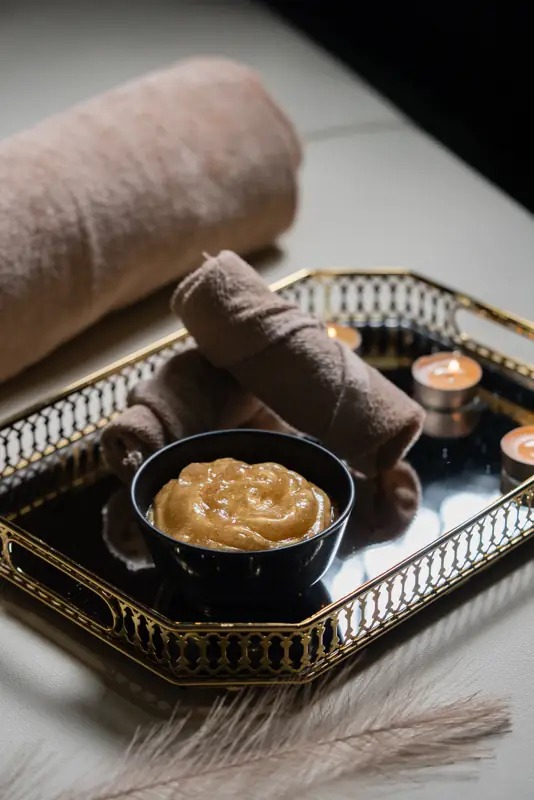 Warm towel on a gold tray with candles